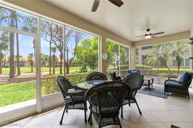 sunroom featuring a ceiling fan and outdoor dining space