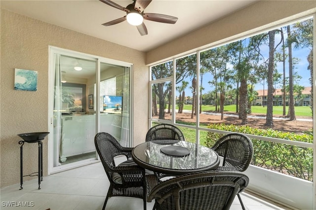 sunroom / solarium featuring outdoor dining area and a ceiling fan