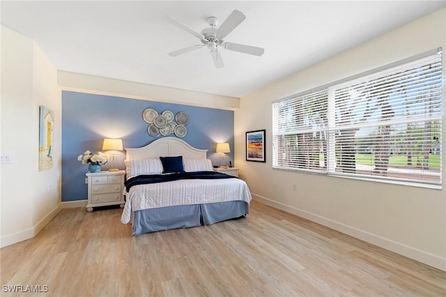 bedroom with baseboards, multiple windows, and wood finished floors