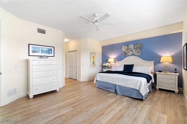 bedroom featuring baseboards, ceiling fan, light wood finished floors, and visible vents