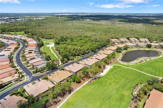 drone / aerial view featuring a water view, a view of trees, view of golf course, and a residential view