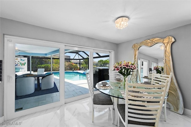 dining space featuring a sunroom and marble finish floor