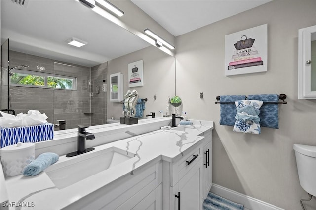 full bathroom featuring a shower stall, double vanity, toilet, a sink, and baseboards