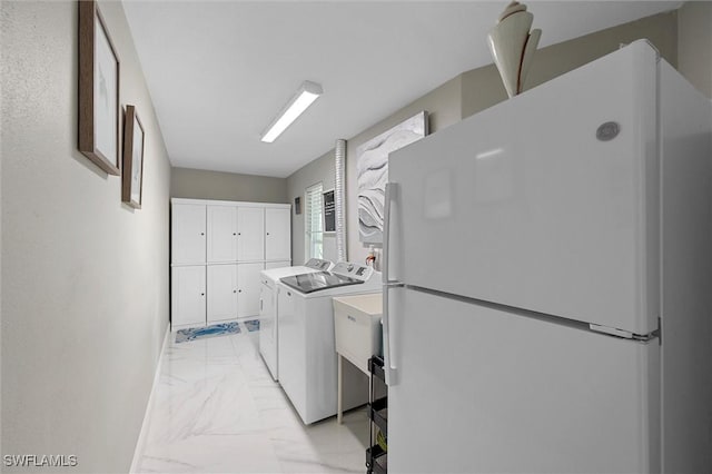 clothes washing area with marble finish floor, cabinet space, separate washer and dryer, and baseboards