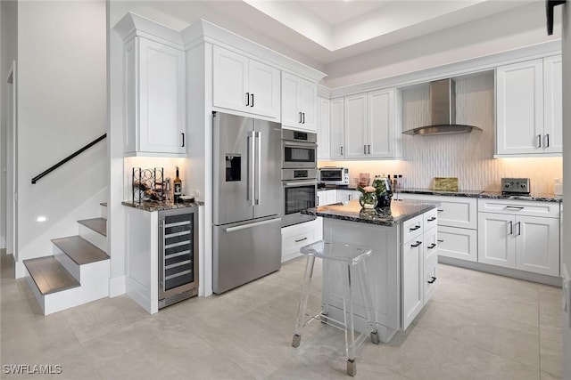 1603 Curlew Ave Unit 1603, Naples, FL 34102 - kitchen featuring a kitchen island, appliances with stainless steel finishes, white cabinets, beverage cooler, and wall chimney exhaust hood