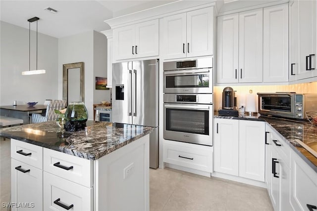 1603 Curlew Ave Unit 1603, Naples, FL 34102 - kitchen with appliances with stainless steel finishes, light tile patterned floors, a toaster, dark stone counters, and white cabinetry