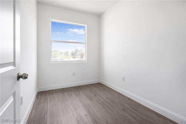empty room featuring wood finished floors and baseboards