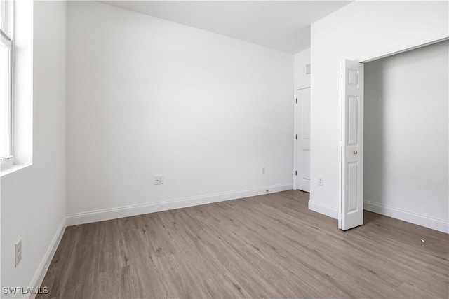 unfurnished bedroom featuring wood finished floors and baseboards
