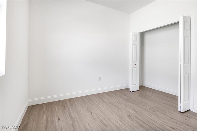 unfurnished bedroom featuring wood finished floors and baseboards