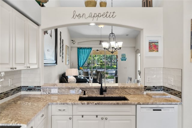 8188 Tauren Ct Unit N342, Naples, FL 34119 - kitchen featuring tasteful backsplash, a sink, white dishwasher, arched walkways, and an inviting chandelier