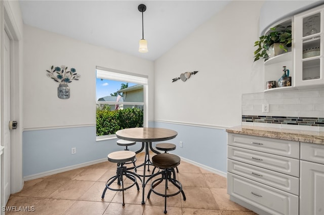 8188 Tauren Ct Unit N342, Naples, FL 34119 - dining area with baseboards, light tile patterned floors, and vaulted ceiling