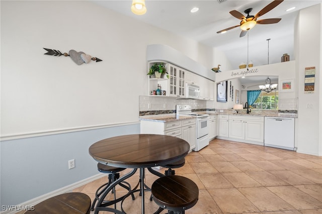 8188 Tauren Ct Unit N342, Naples, FL 34119 - kitchen with white appliances, white cabinets, ceiling fan with notable chandelier, backsplash, and a sink