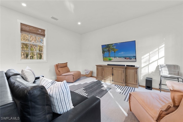 living area featuring recessed lighting, visible vents, and light carpet
