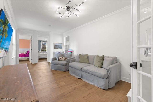 living room with crown molding, baseboards, and wood finished floors