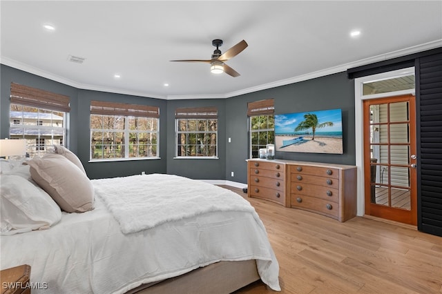 bedroom featuring crown molding, visible vents, multiple windows, and wood finished floors