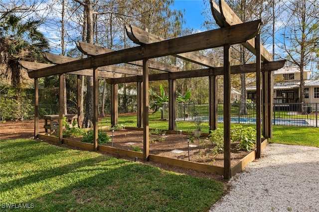 view of community featuring fence, a pool, a yard, and a vegetable garden