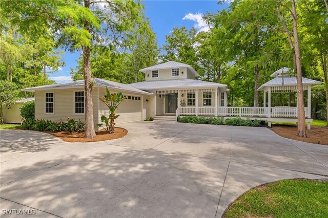 5271 Cherry Wood Dr, Naples, FL 34119 - view of front of house featuring a gazebo, driveway, a garage, a metal roof, and covered porch