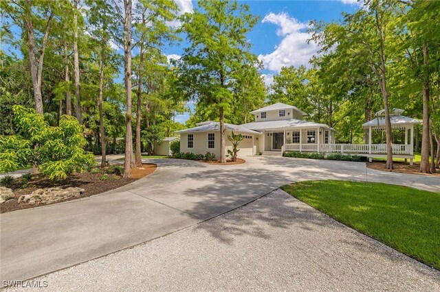 5271 Cherry Wood Dr, Naples, FL 34119 - view of front of home with curved driveway, a gazebo, an attached garage, and a porch