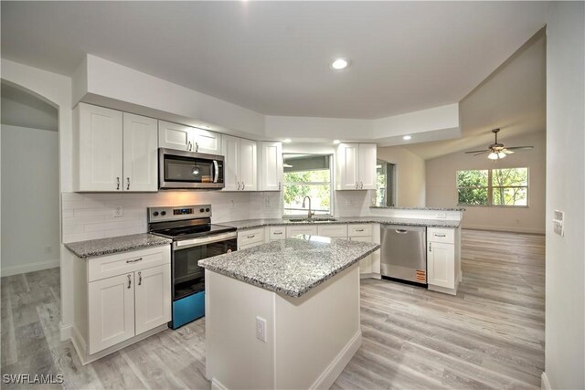 2381 Webster Rd, Alva, FL 33920 - kitchen featuring stainless steel appliances, white cabinets, a sink, baseboards, and a peninsula