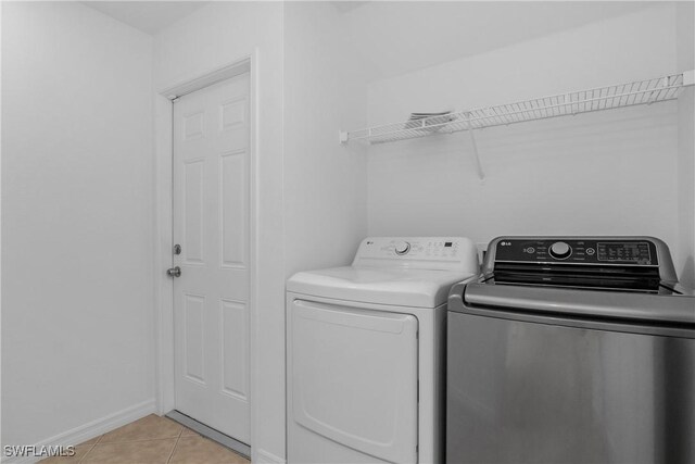 1227 Damen St E, Lehigh Acres, FL 33974 - laundry room featuring independent washer and dryer, light tile patterned floors, and baseboards