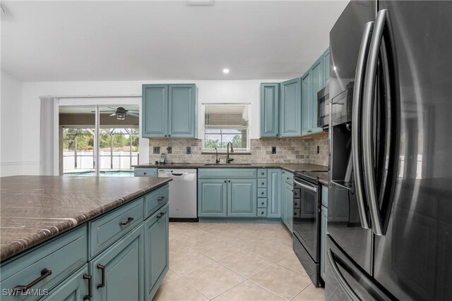 1227 Damen St E, Lehigh Acres, FL 33974 - kitchen with appliances with stainless steel finishes, a sink, decorative backsplash, healthy amount of natural light, and recessed lighting