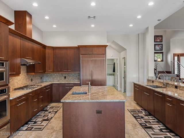 580 Goldcoast Ct, Marco Island, FL 34145 - kitchen with a kitchen island with sink, stainless steel gas stovetop, decorative backsplash, and a sink