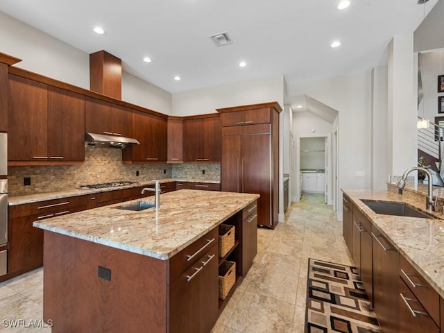 580 Goldcoast Ct, Marco Island, FL 34145 - kitchen with a sink, stainless steel gas cooktop, a center island with sink, and tasteful backsplash