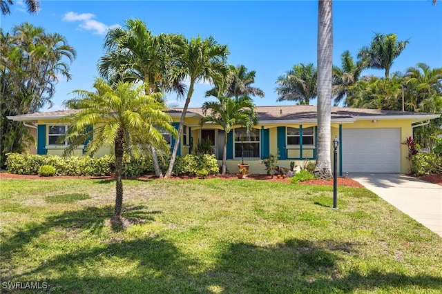 view of front of home with stucco siding, concrete driveway, a front yard, and a garage