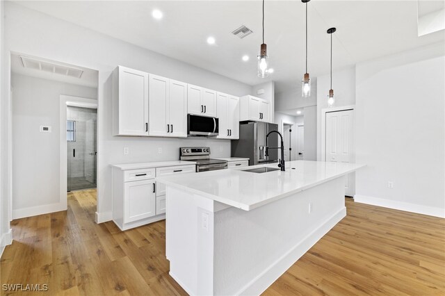 2706 39th St W, Lehigh Acres, FL 33971 - kitchen featuring a sink, appliances with stainless steel finishes, visible vents, baseboards, and a kitchen island with sink
