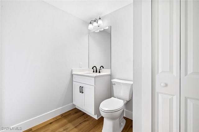 2706 39th St W, Lehigh Acres, FL 33971 - bathroom featuring wood finished floors, vanity, toilet, and baseboards