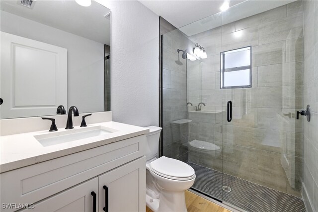 2706 39th St W, Lehigh Acres, FL 33971 - full bathroom with visible vents, a stall shower, toilet, wood finished floors, and vanity