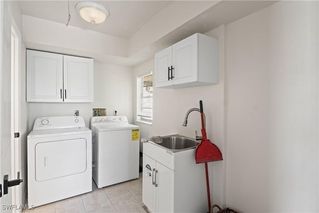 washroom featuring independent washer and dryer, light tile patterned floors, a sink, and cabinet space