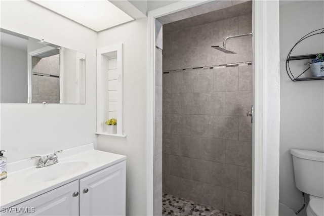 bathroom featuring vanity, a shower stall, and toilet