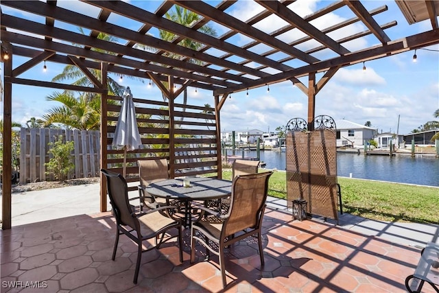 view of patio featuring fence, a pergola, a water view, and outdoor dining space