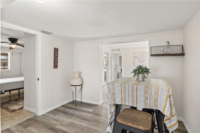 dining room with visible vents, baseboards, ceiling fan, and wood finished floors