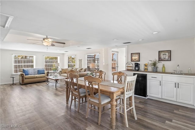 dining area featuring visible vents, dark wood-style floors, recessed lighting, a tray ceiling, and a ceiling fan