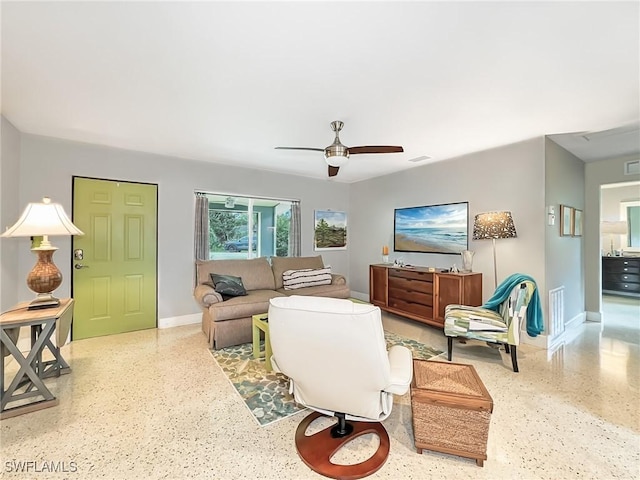 living room with baseboards, visible vents, ceiling fan, and speckled floor