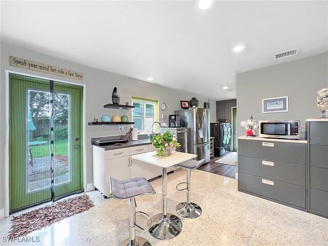 kitchen with open shelves, appliances with stainless steel finishes, visible vents, gray cabinetry, and recessed lighting