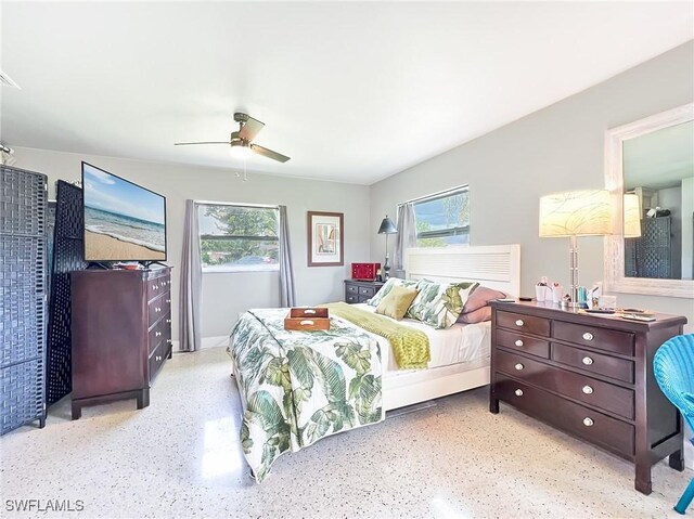 bedroom featuring multiple windows, speckled floor, and ceiling fan