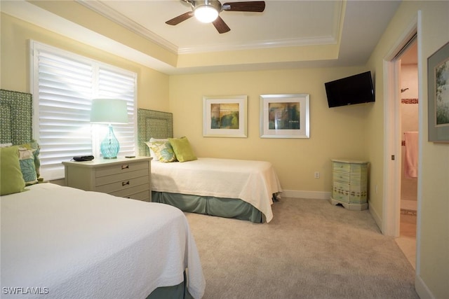 bedroom featuring a tray ceiling, baseboards, ornamental molding, light carpet, and a ceiling fan