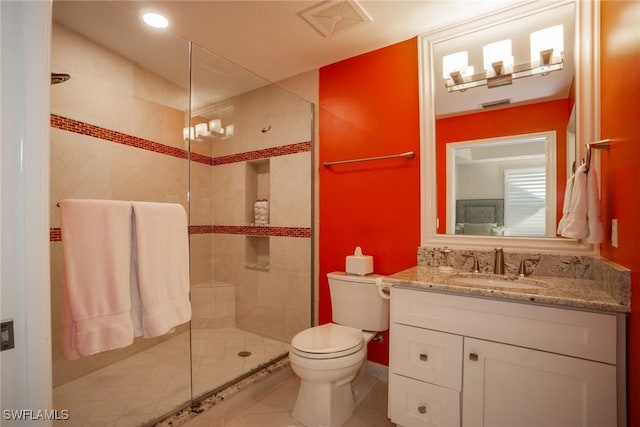 full bathroom with tile patterned floors, vanity, toilet, and tiled shower