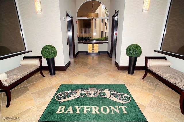 hall with elevator and baseboards
