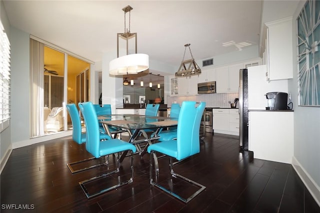 dining space featuring dark wood-style floors, visible vents, and baseboards