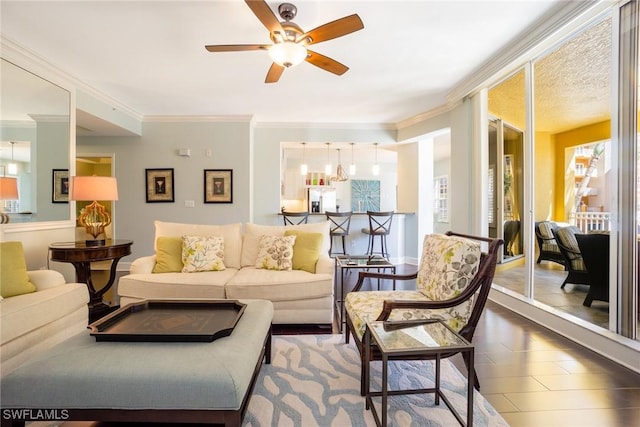 living room with crown molding, ceiling fan, and plenty of natural light