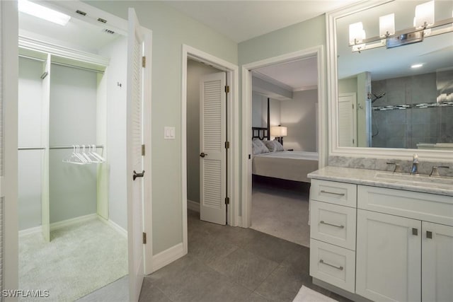 bathroom with connected bathroom, a shower stall, baseboards, a closet, and vanity