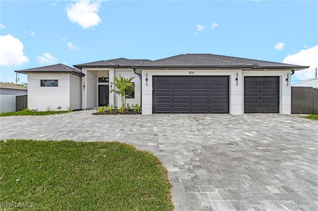 806 Santa Barbara Blvd, Cape Coral, FL 33991 - prairie-style house with fence, decorative driveway, an attached garage, and stucco siding