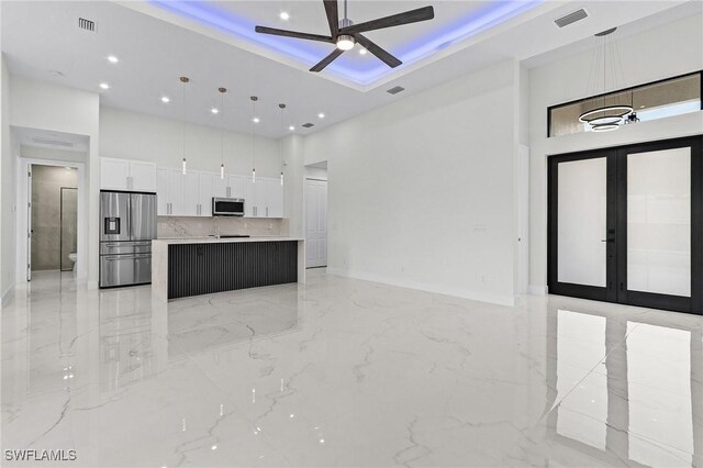 806 Santa Barbara Blvd, Cape Coral, FL 33991 - kitchen with stainless steel appliances, white cabinetry, a ceiling fan, open floor plan, and a towering ceiling