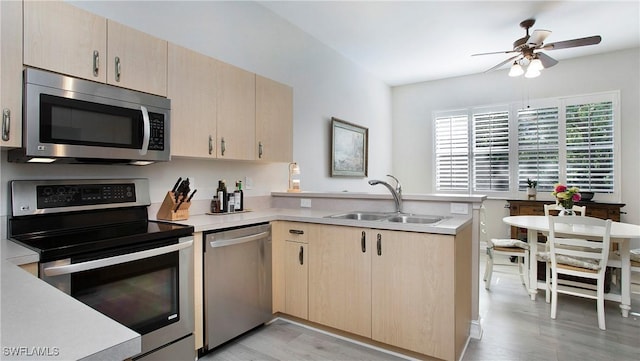 761 Grand Rapids Blvd, Naples, FL 34120 - kitchen featuring appliances with stainless steel finishes, a sink, a peninsula, light brown cabinetry, and light countertops