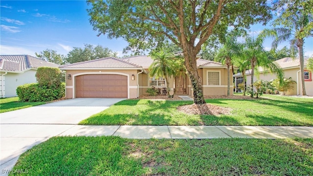 761 Grand Rapids Blvd, Naples, FL 34120 - mediterranean / spanish-style house with stucco siding, an attached garage, concrete driveway, a tiled roof, and a front yard