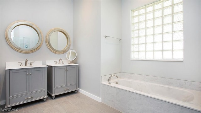 761 Grand Rapids Blvd, Naples, FL 34120 - full bathroom with two vanities, a garden tub, baseboards, and tile patterned flooring